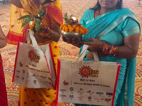 Visitors holding Sun Neo branded gift bags at the mela