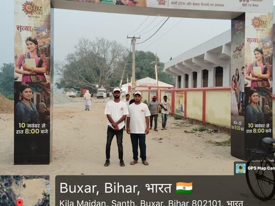 Sun Neo team standing at the branded entrance gate in daylight
