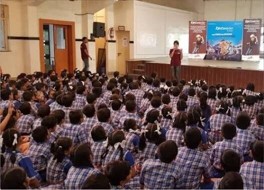 Rudra team presenting a road safety awareness program to students in a school auditorium