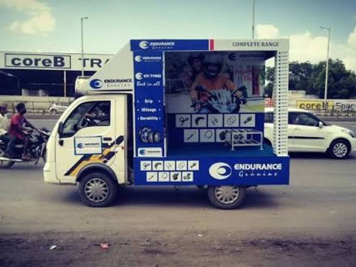 Branded promotional van on a road show through a local market